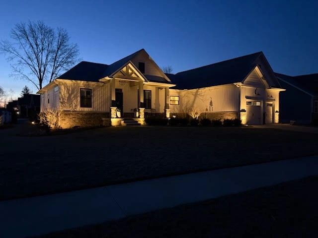 Residential house exterior at night with architectural lighting